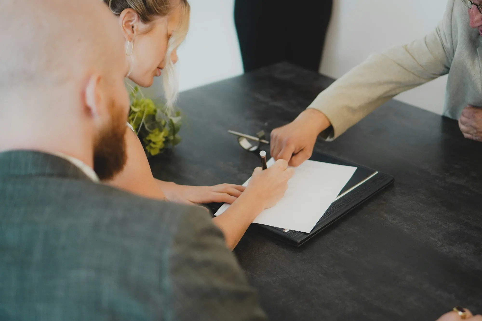 Two people exchanging a signed document at a table