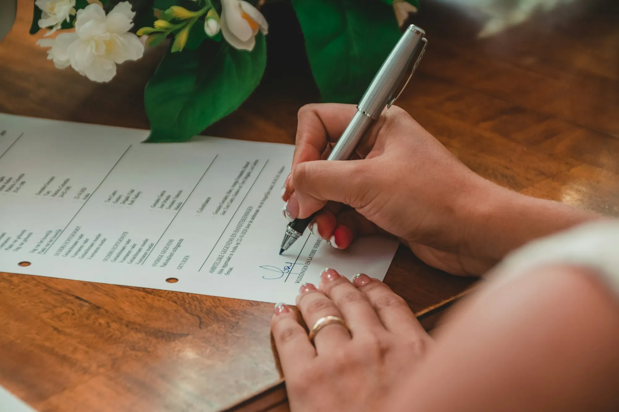 Hand writing on a document with a silver pen